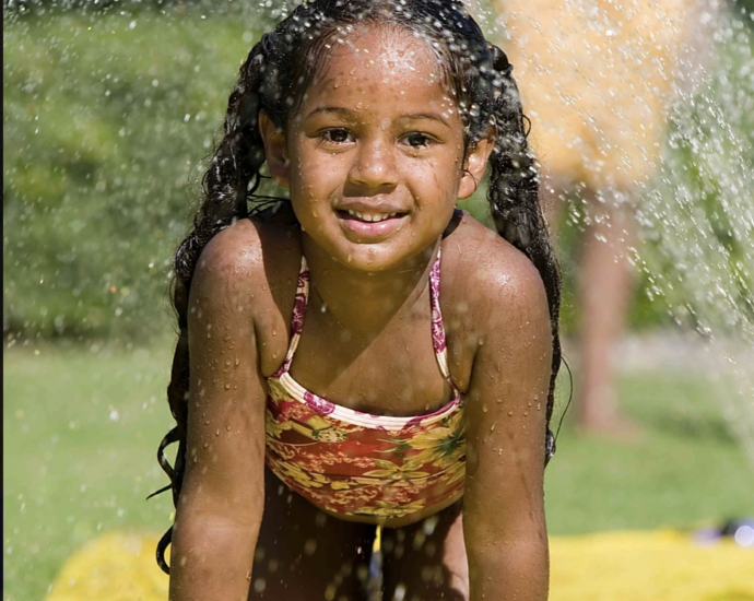 Smiling girl playing on slip and slide