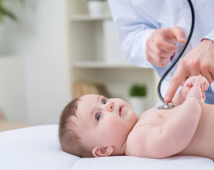 Baby having his heart listened to by doctor