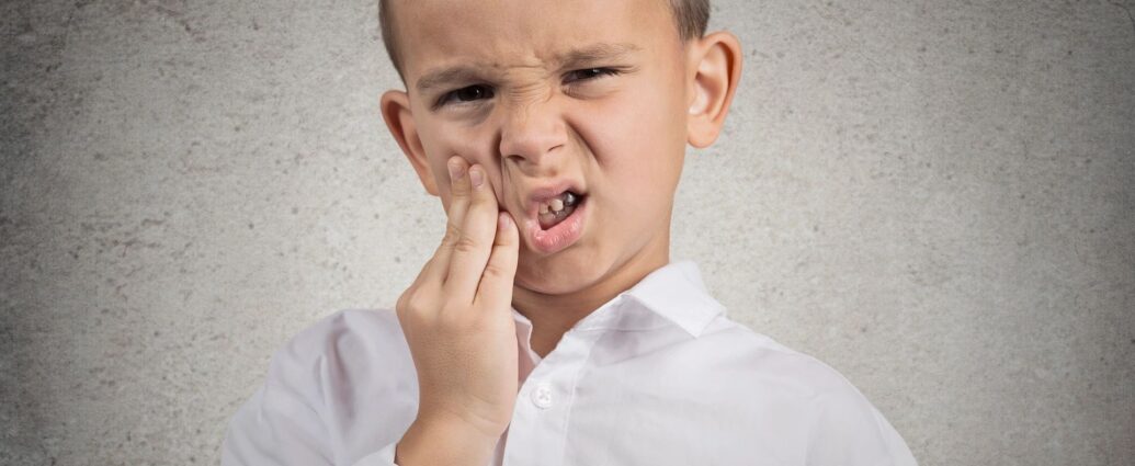 Child holding his mouth from tooth ache