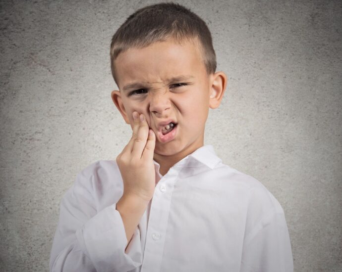 Child holding his mouth from tooth ache