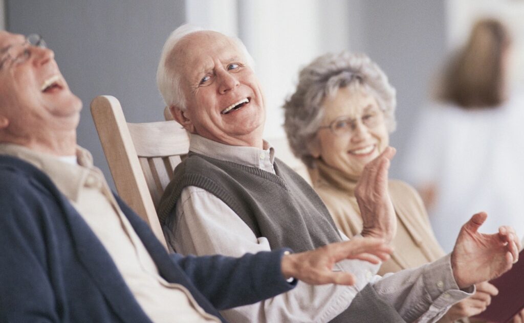 happy, laughing seniors sitting in chairs